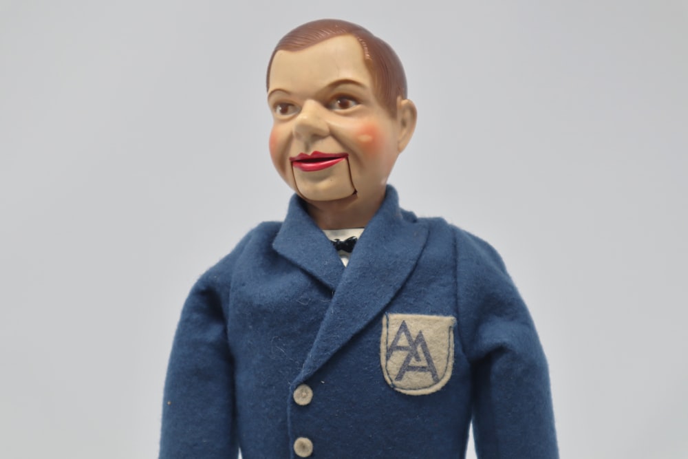 a doll with a fake head and a blue coat