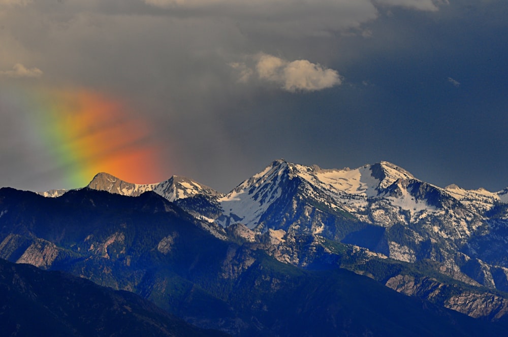 a rainbow in the sky over a mountain range