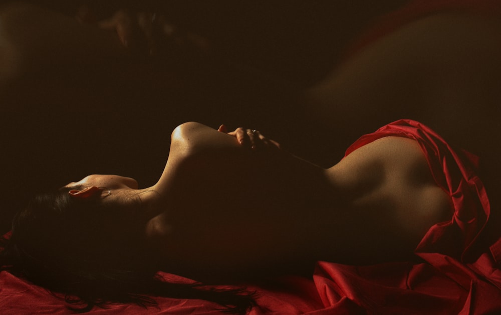 a woman in a red dress laying on a bed