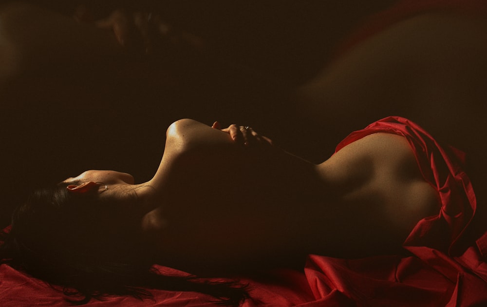 eine Frau in einem roten Kleid, die auf einem Bett liegt
