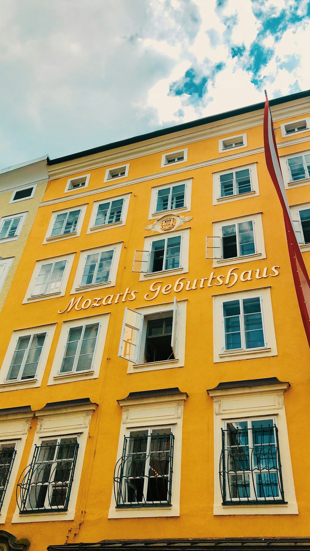 un grand bâtiment jaune avec une horloge sur le devant