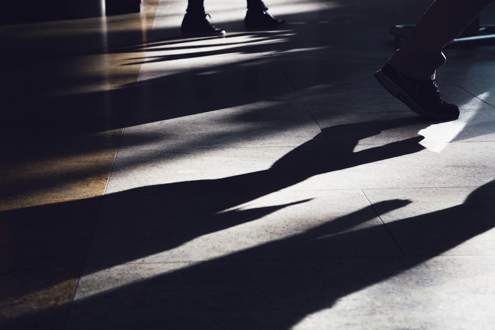 a shadow of a person walking on a sidewalk