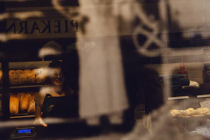 Soft morning light illuminating a bakery window filled with breads
