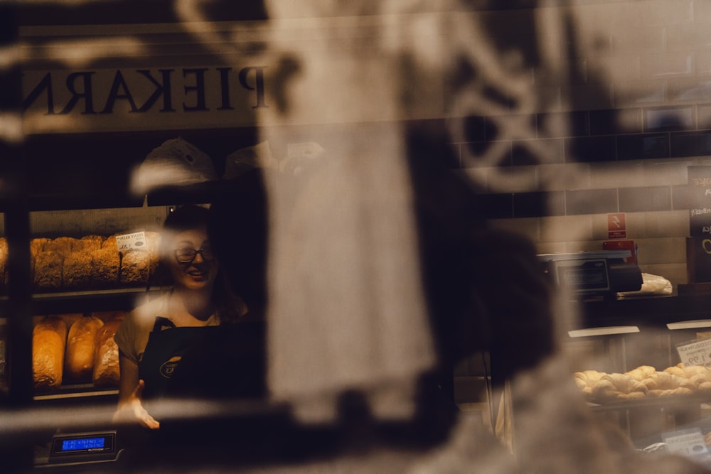 a woman standing in front of a bakery window