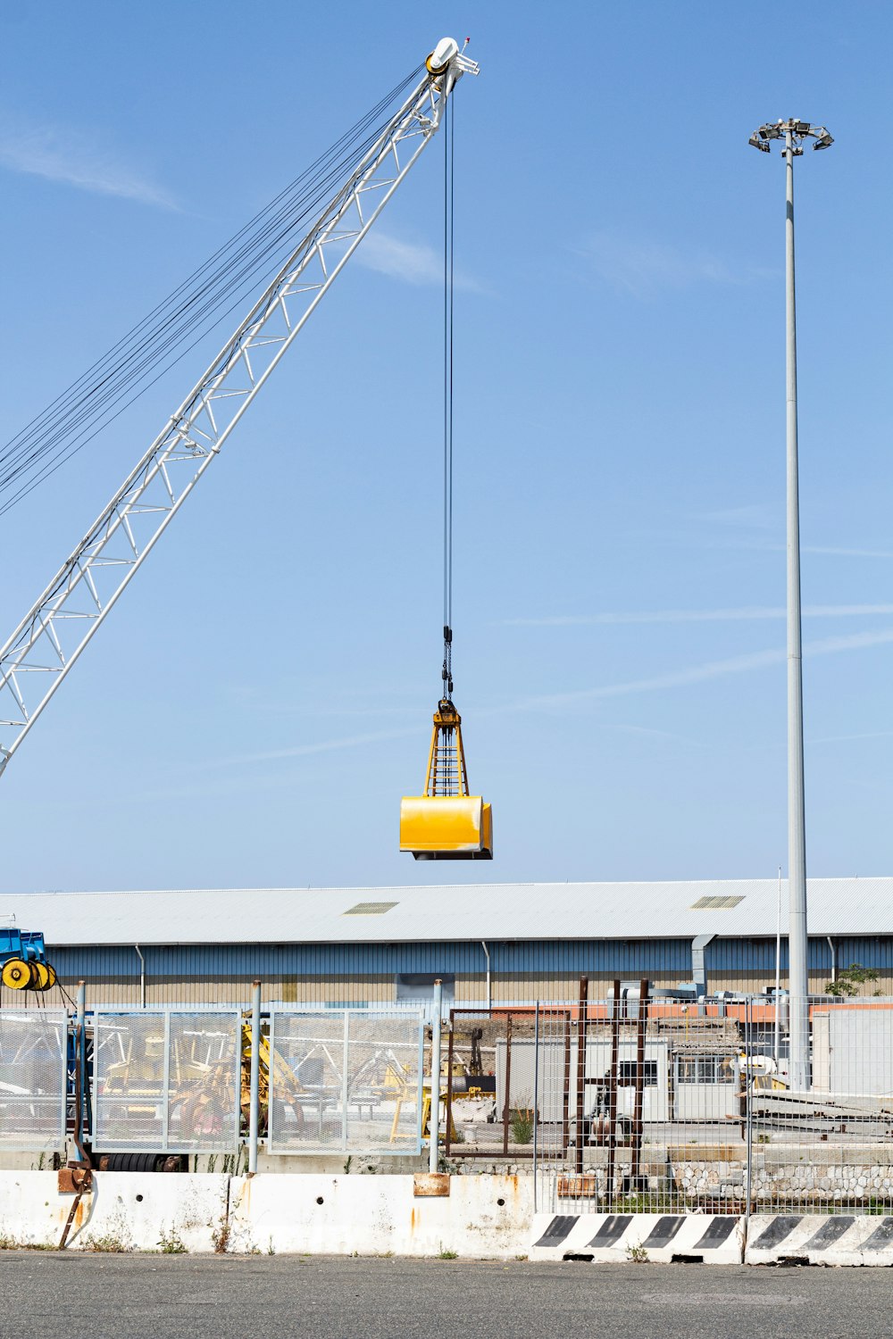 crane holding yellow box over building during daytime