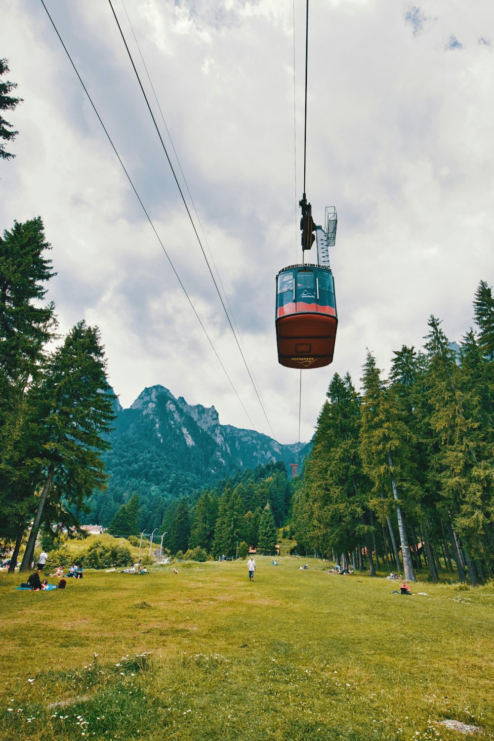 people sitting and standing near mountain at daytime