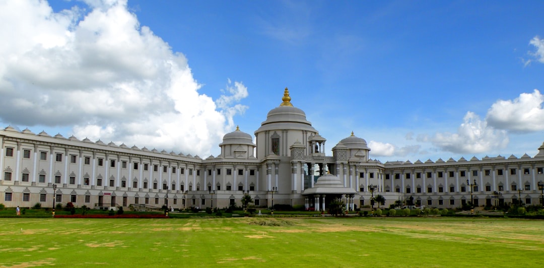 a large white building sitting on top of a lush green field