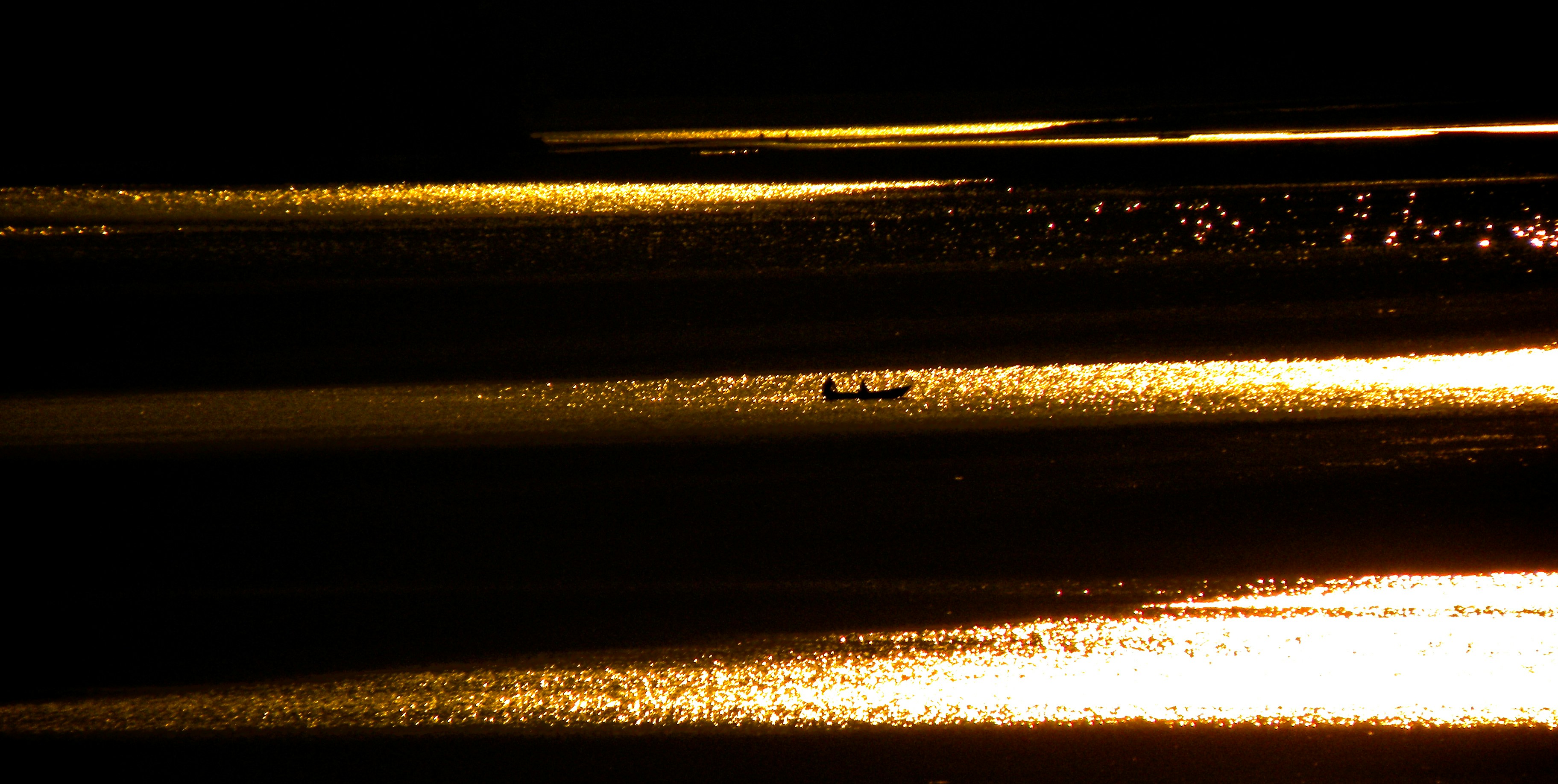 Glittering sunlight reflection on Fewa Lake in the evening.