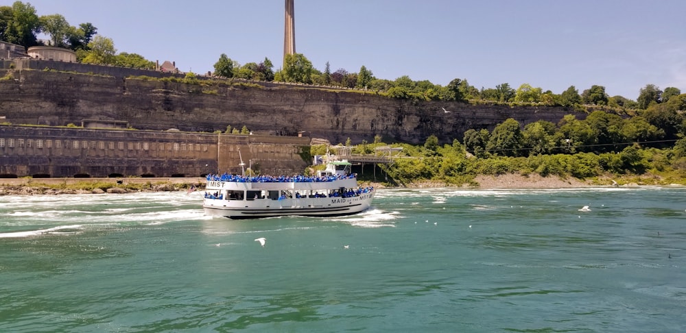 white and blue boat at the river during daytime