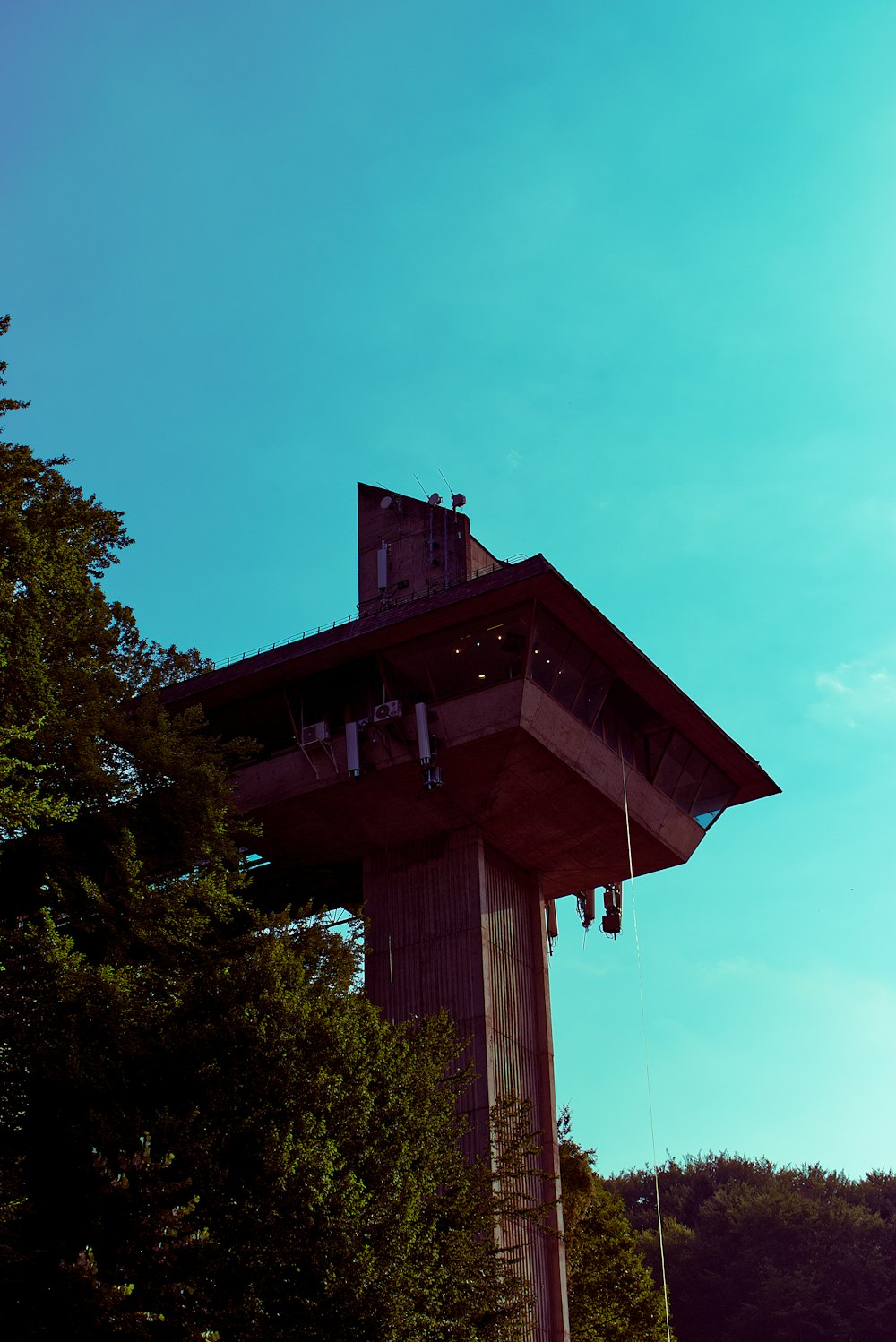 brown tall tower near tree during daytime