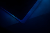 An abstract image with overlapping blue shapes and gradients. The composition creates a sense of depth and complexity through the use of dark and light shades.