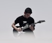 man playing black and white electric guitar