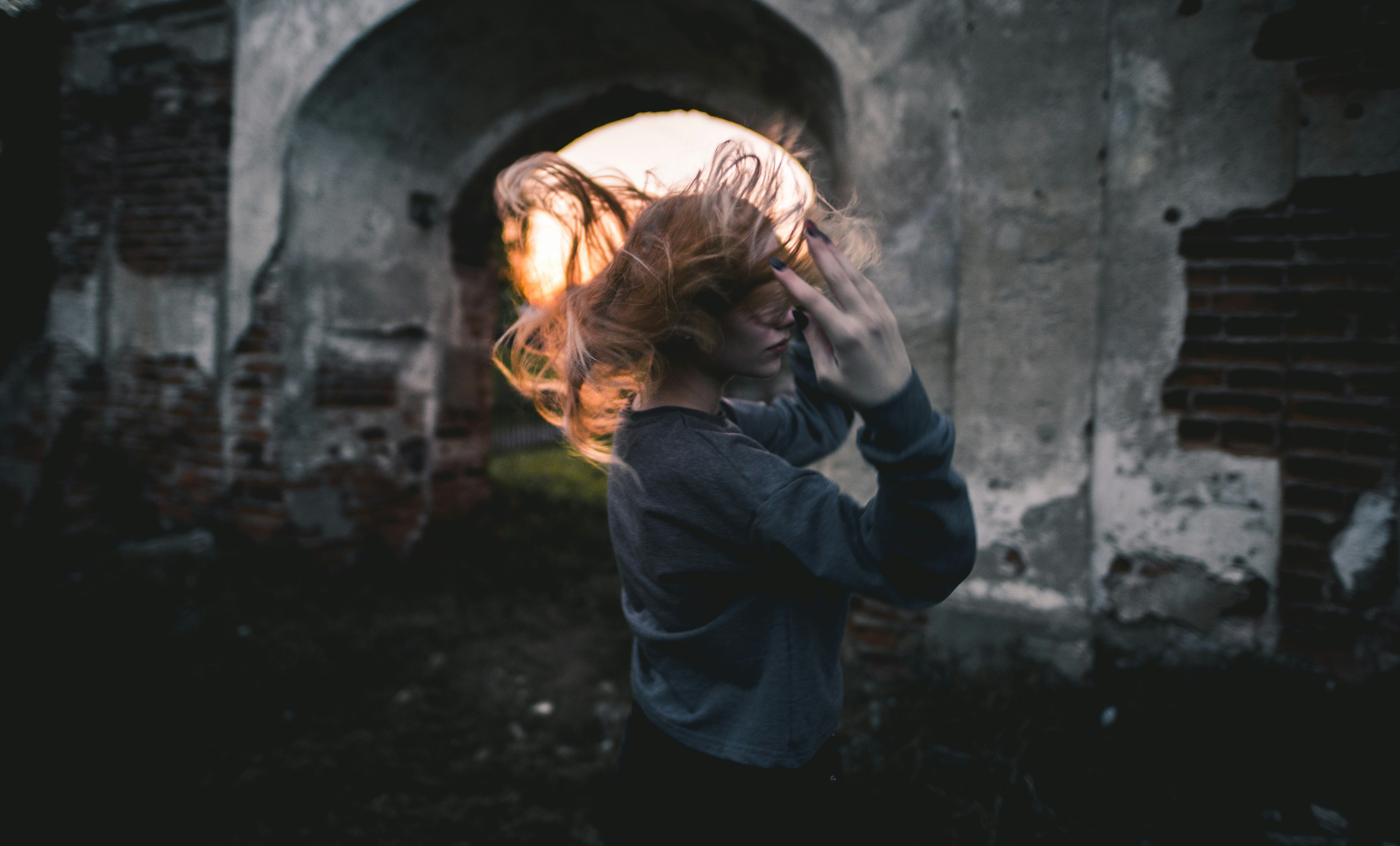 woman in gray long-sleeved shirt flipping hair