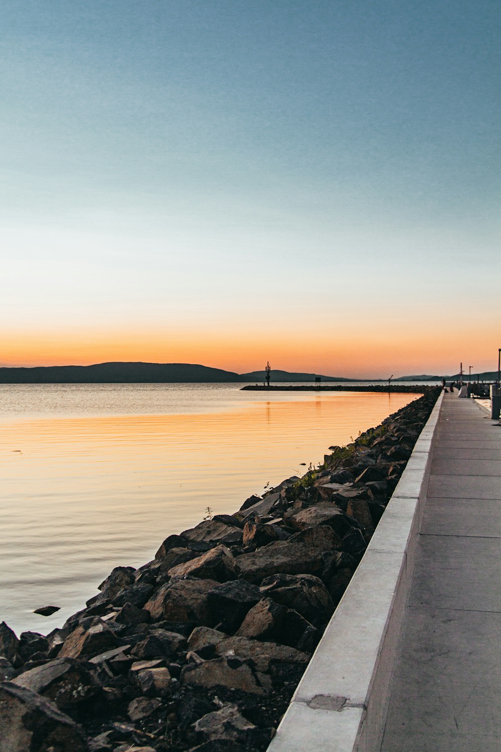 body of water beside rocks during daytime