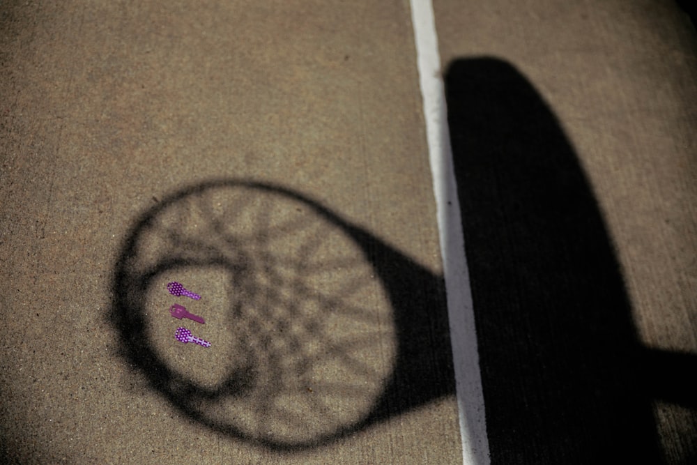 shadow of basketball system on gray pavement surface