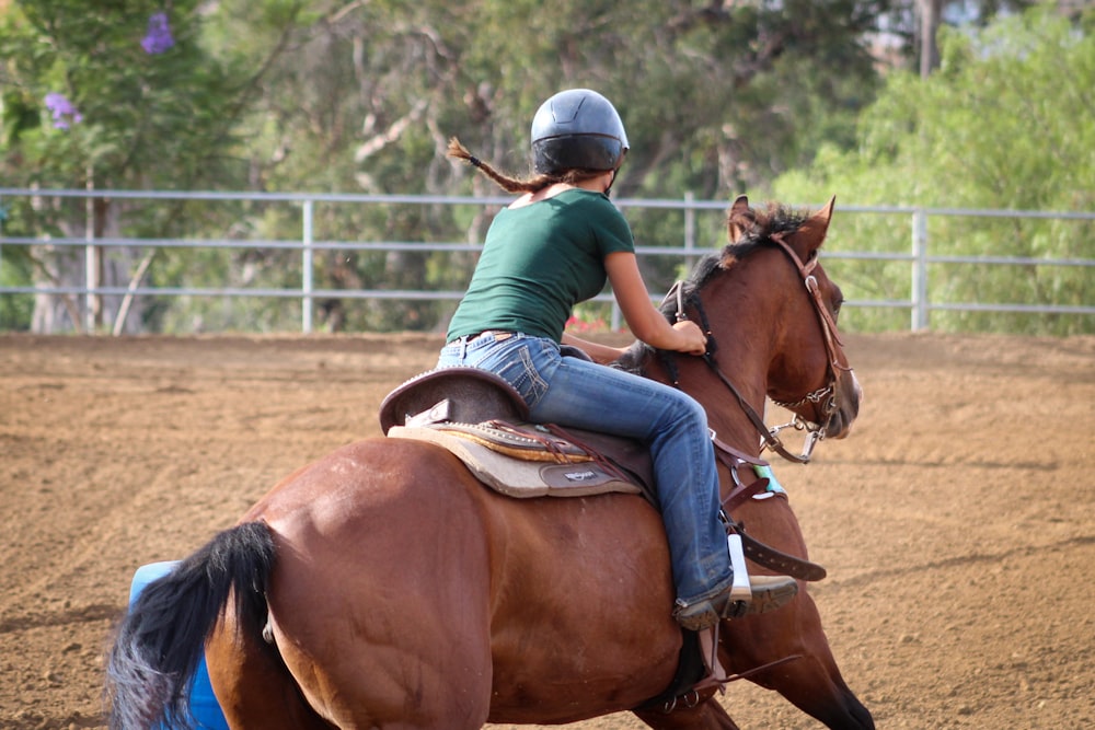 woman riding on brown horse