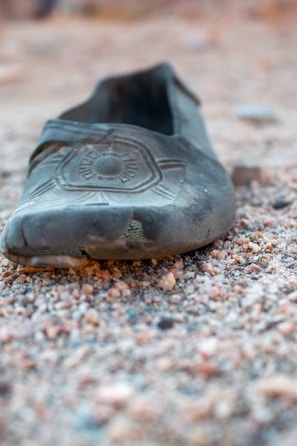 Close-up of worn-out shoes on a dusty trail symbolizing the long journey.