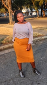 A model wearing a straight-cut culotte skirt with pockets, walking confidently on a sunlit street.