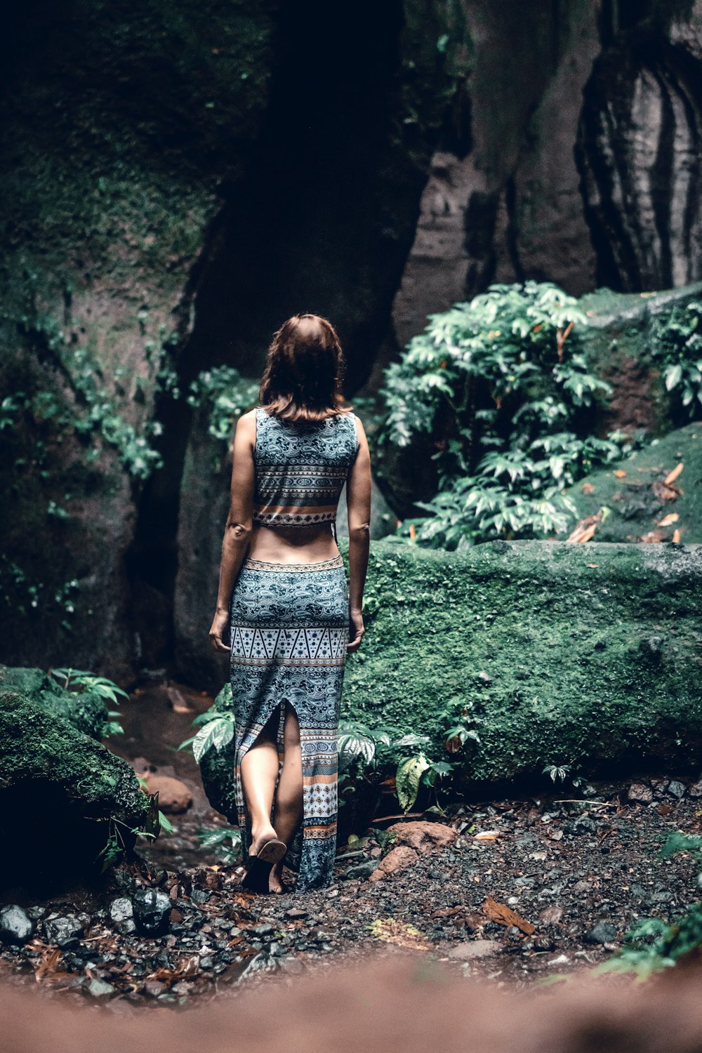 woman walking towards cave
