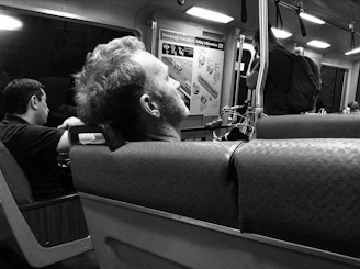 A soft neck wrap pillow draped around a traveler’s neck during a train ride.