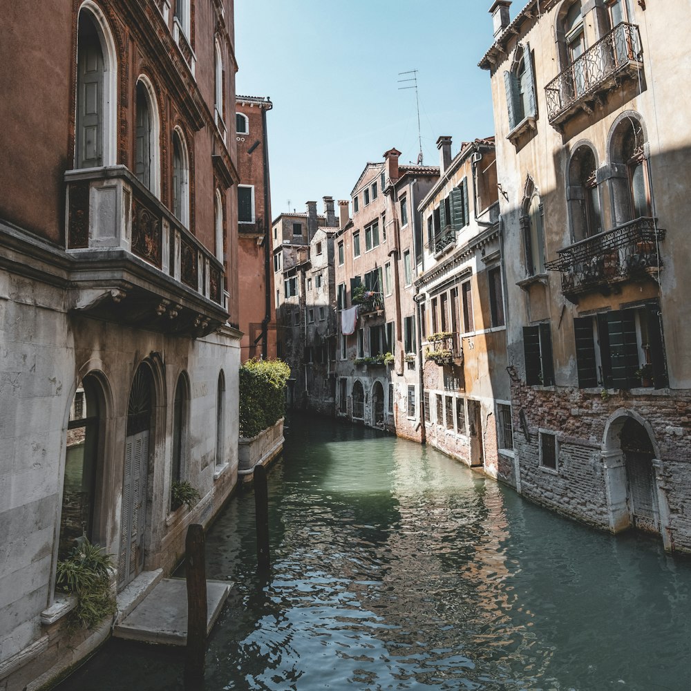 canal between buildings during day