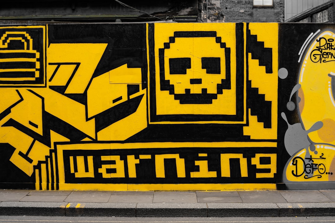 yellow and black Warning graffiti,