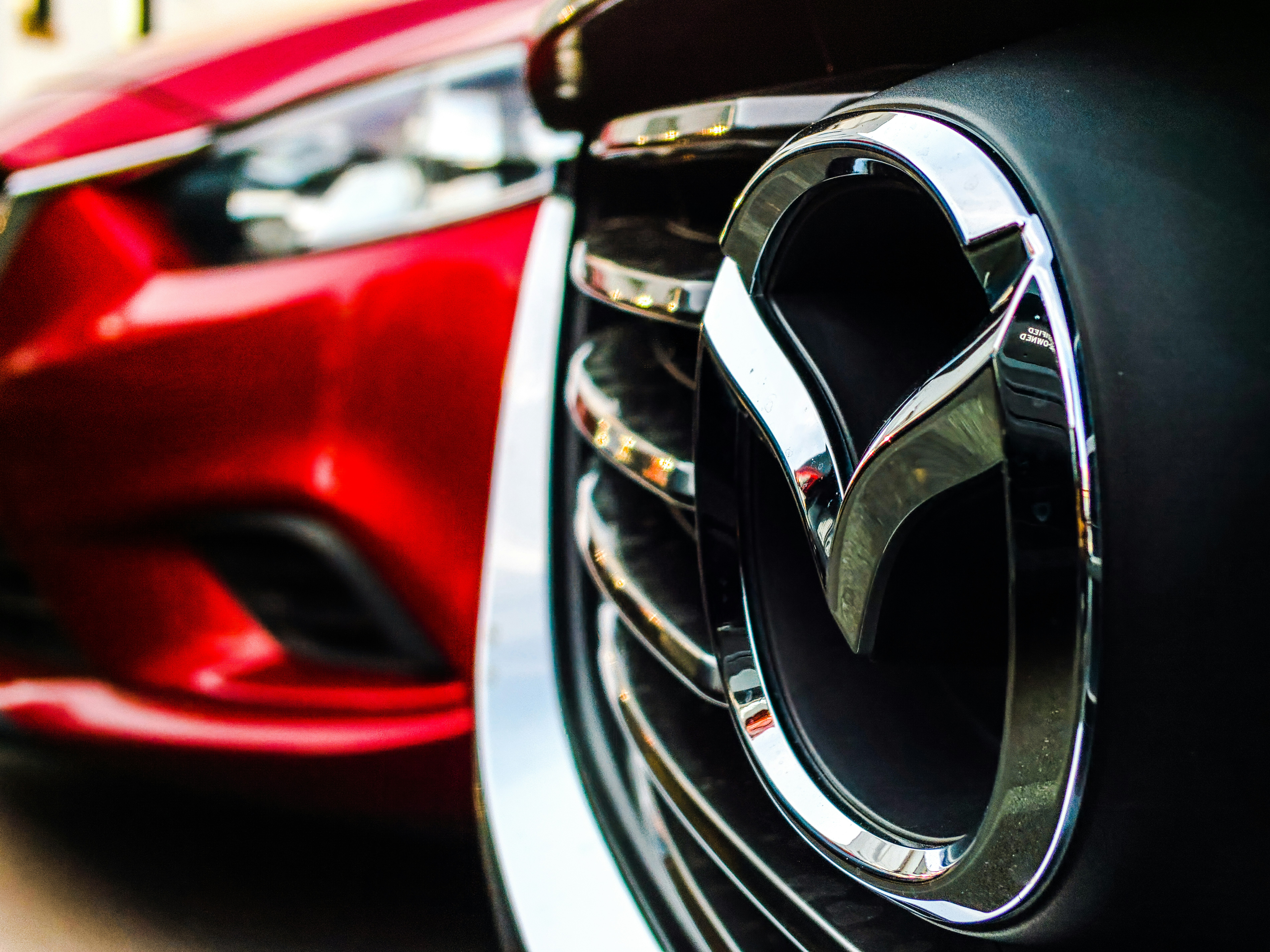 Close up of a Mazda 6's front emblem during sunset.
