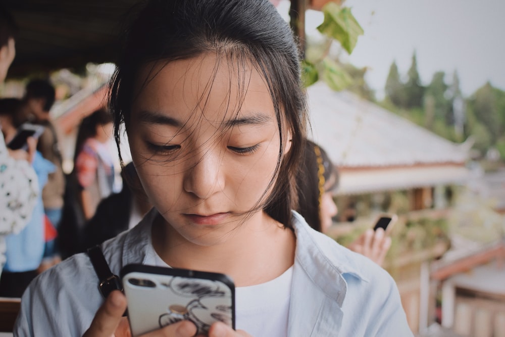 woman holding black and white Android smartphone