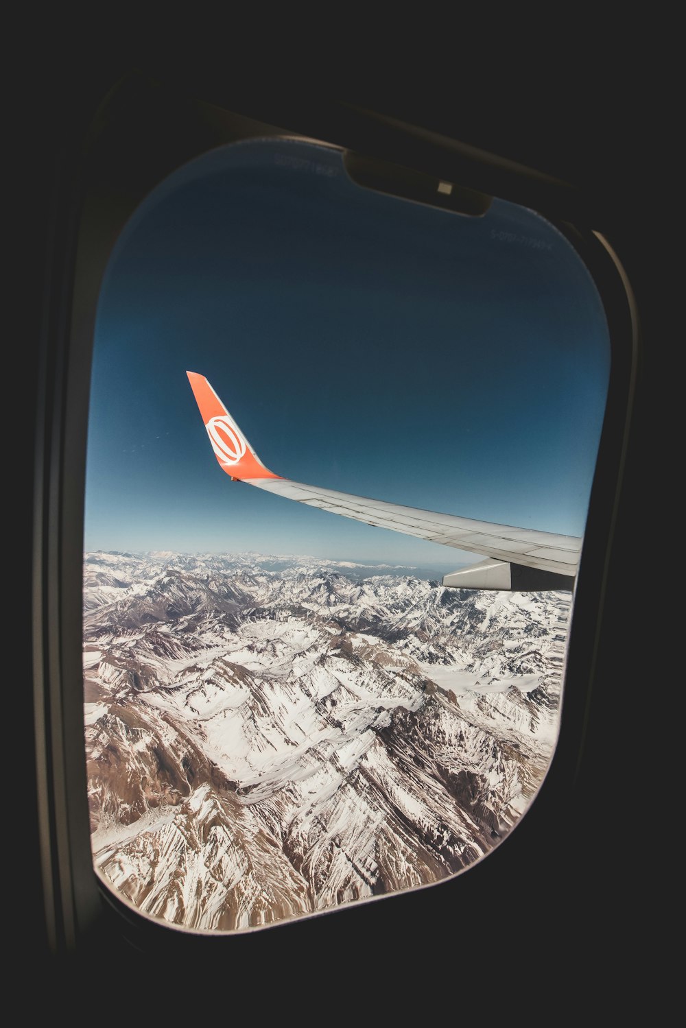 white and orange airplane tail viewing mountain