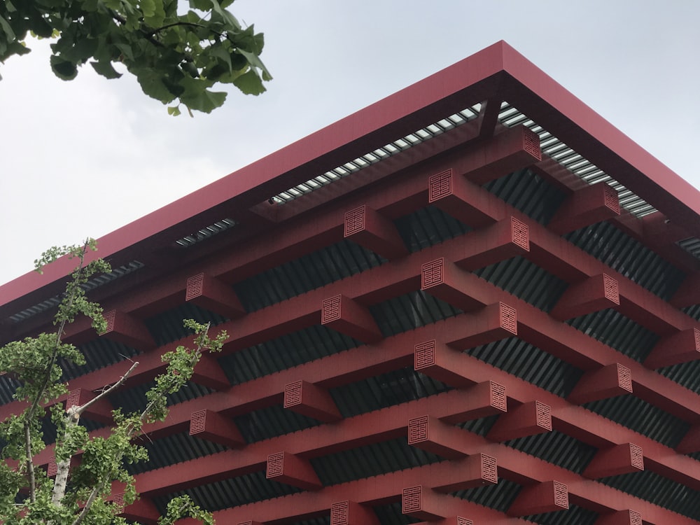 red building photo besides green trees