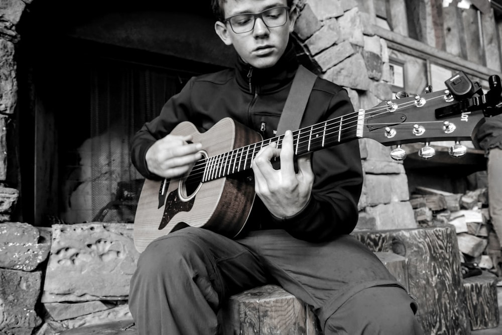 men holding a guitar grey-scale photography