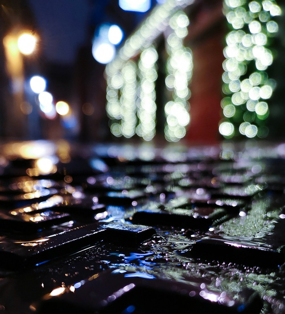 a close up of a computer keyboard with a lot of lights in the background