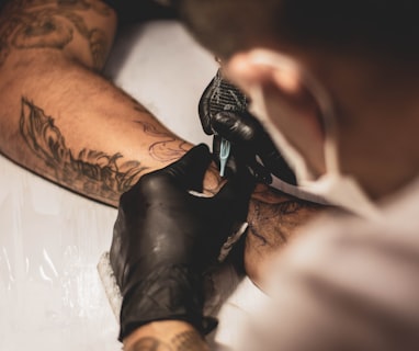 shallow focus photo of person tattooing person's right arm