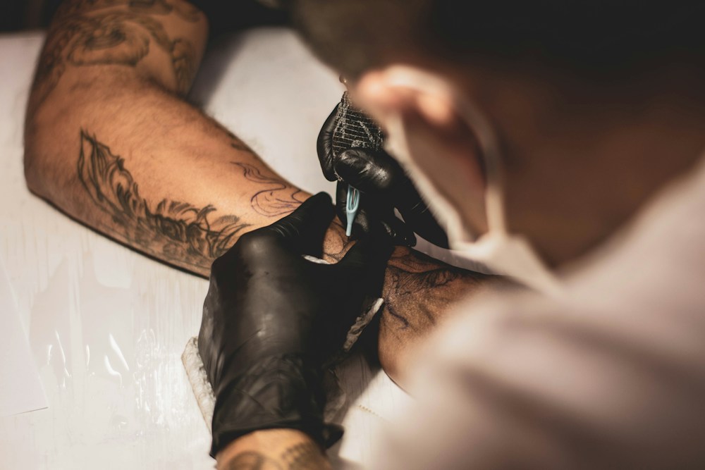 Artist at work on a forearm piece in the studio