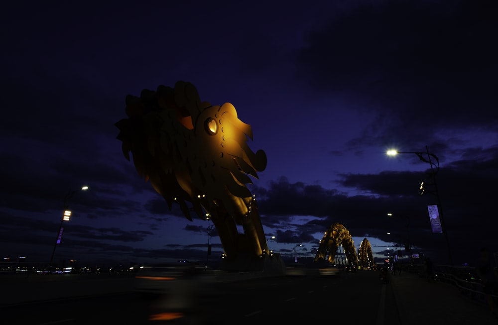 brown dragon sculpture outdoors near building during night