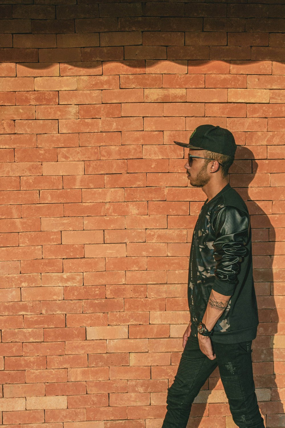 man walking near brick wall