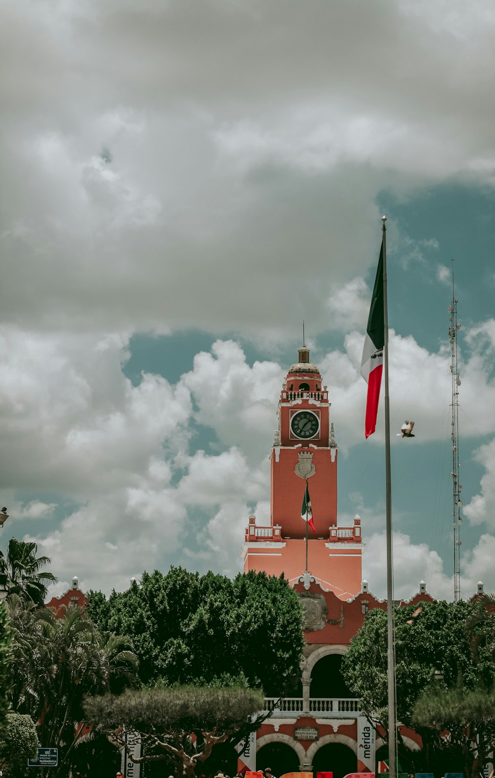 pink painted tower clock under white clouds