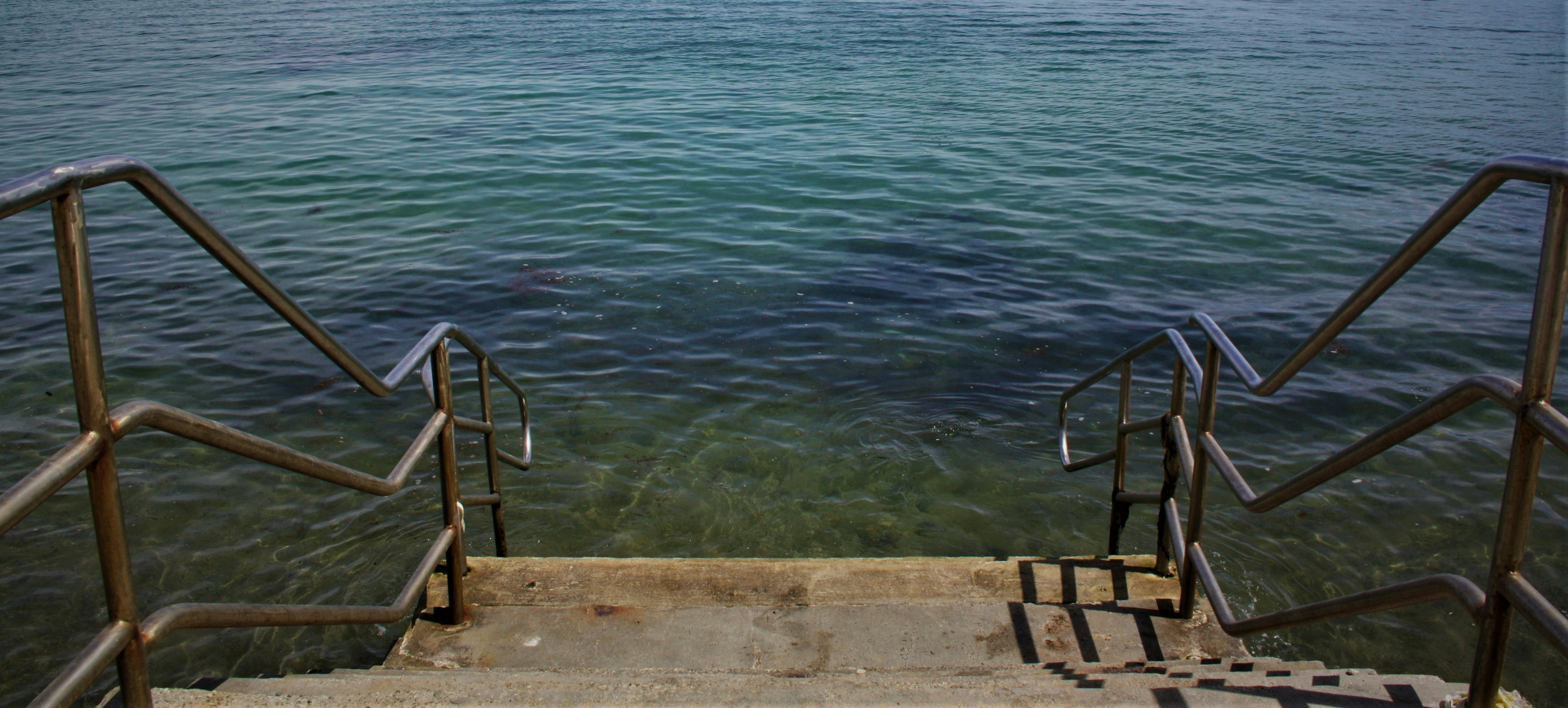 gray metal railings towards into the sea