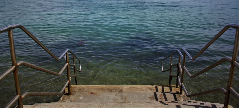 gray metal railings towards into the sea