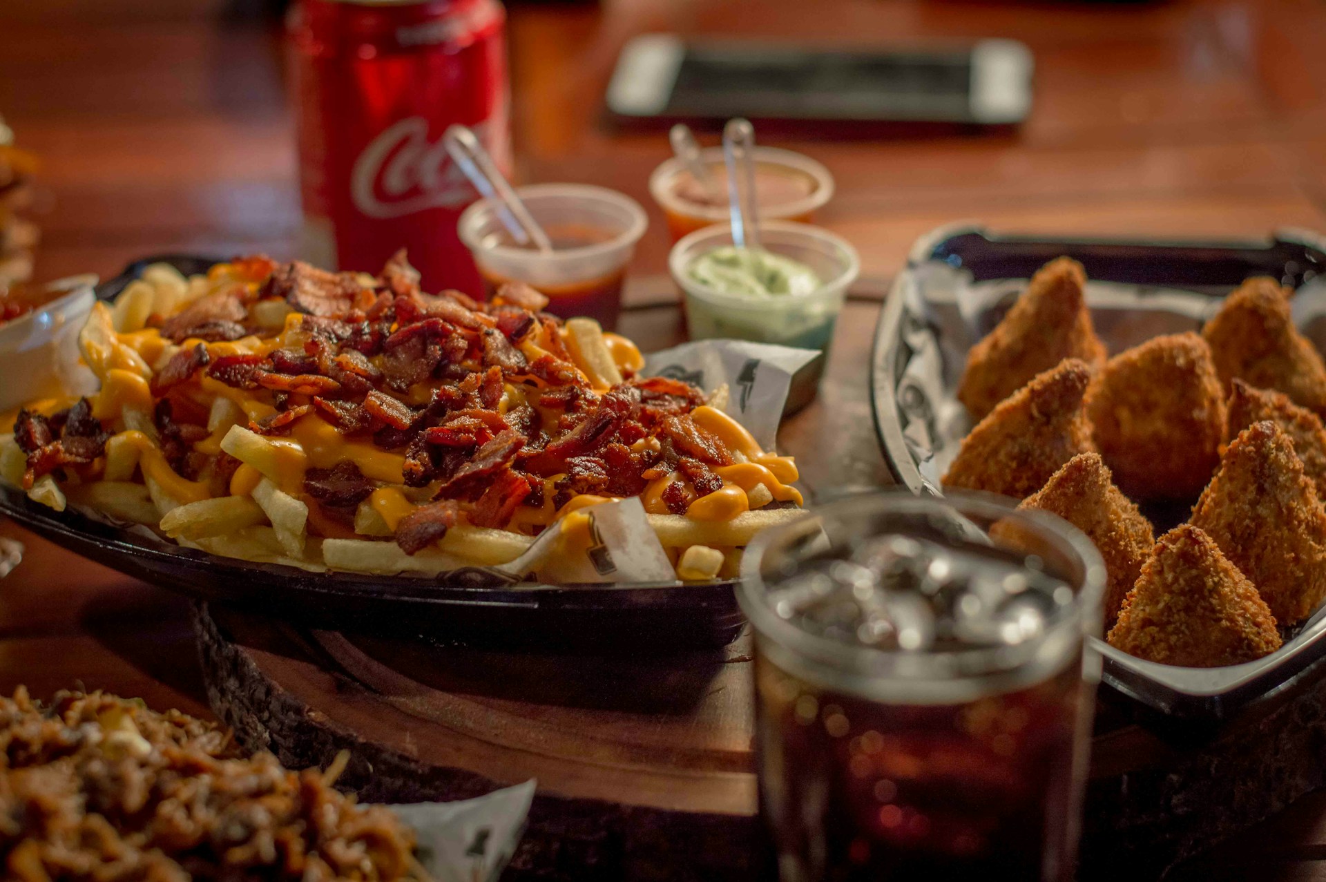 A colorful tray with an assortment of classic American sides: crispy fries, tangy coleslaw, and a small bowl of creamy mac and cheese.