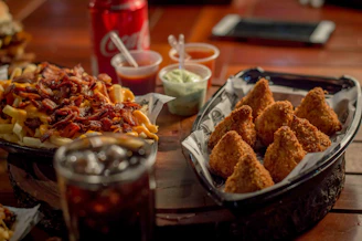 A colorful spread of munchies including loaded fries and cheesy snacks on a wooden table.