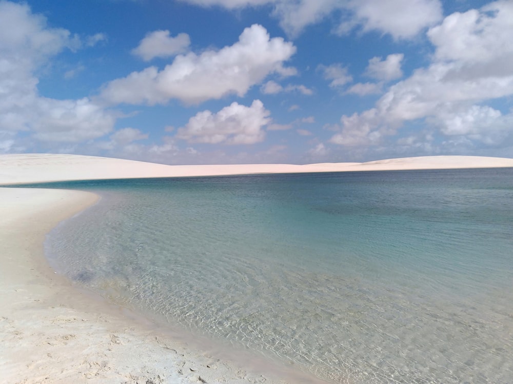 white sand beach under cloudy sky during daytime