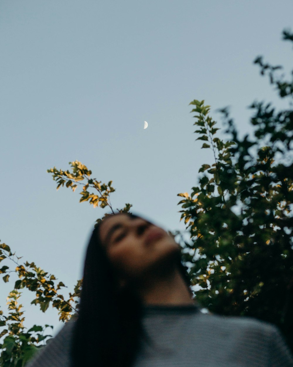 a woman looking up at the moon in the sky