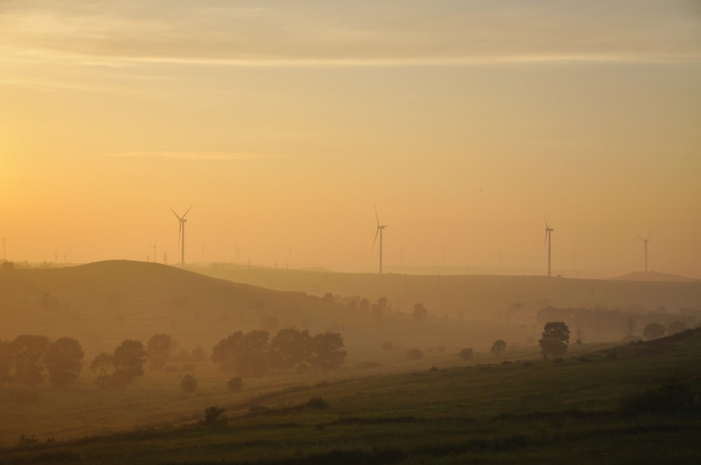 three windmills in a hill during daytime