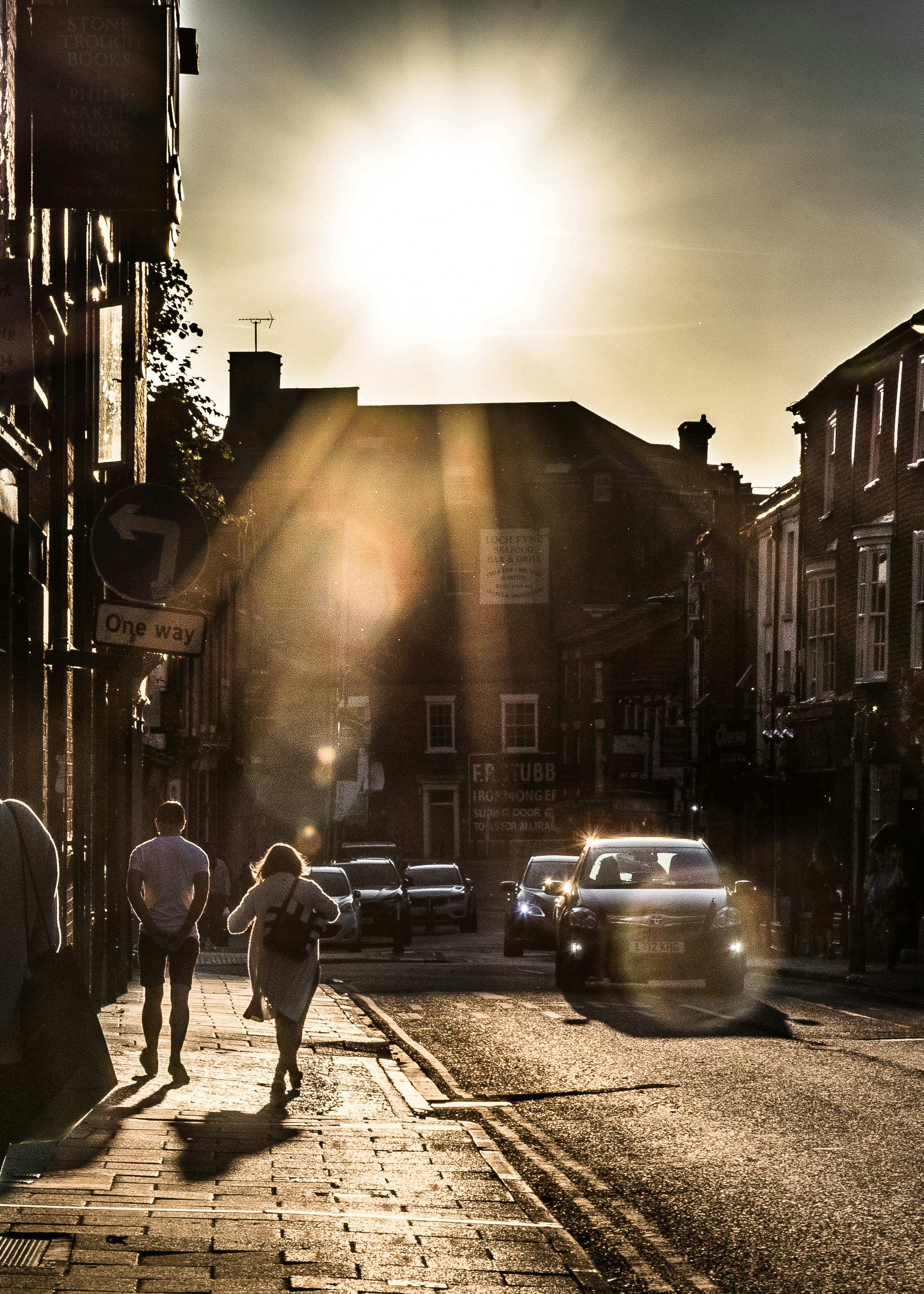 A lovely couple is walking along the street in the evening with the sun light.