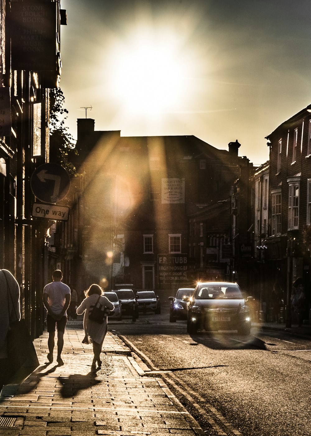 two person standing beside road during golden hour