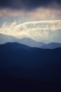 An artistic representation of space with layered mountains and dark background.
