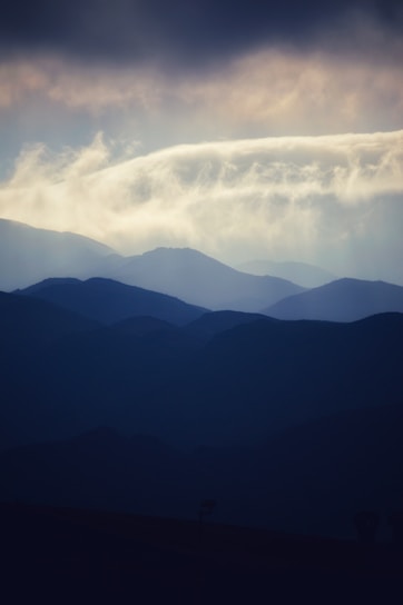 An artistic representation of space with layered mountains and dark background.