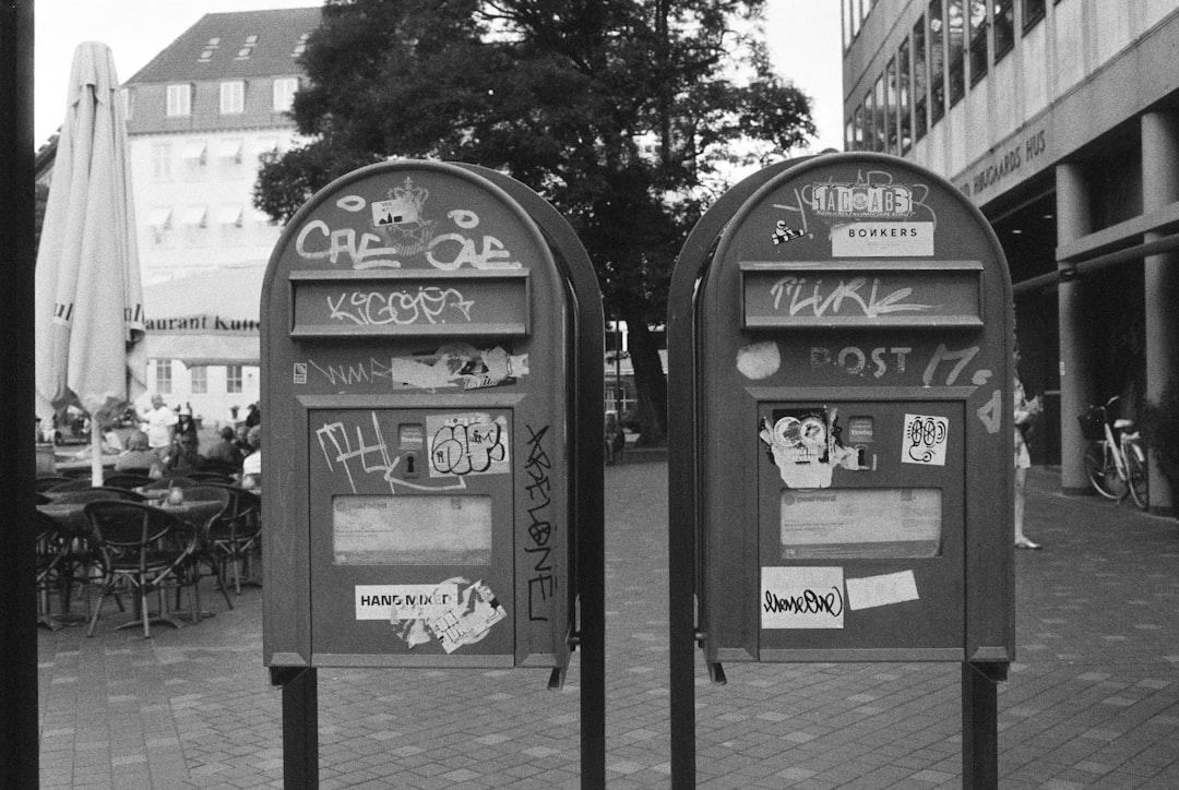 grayscale photo of two metal garbage cans