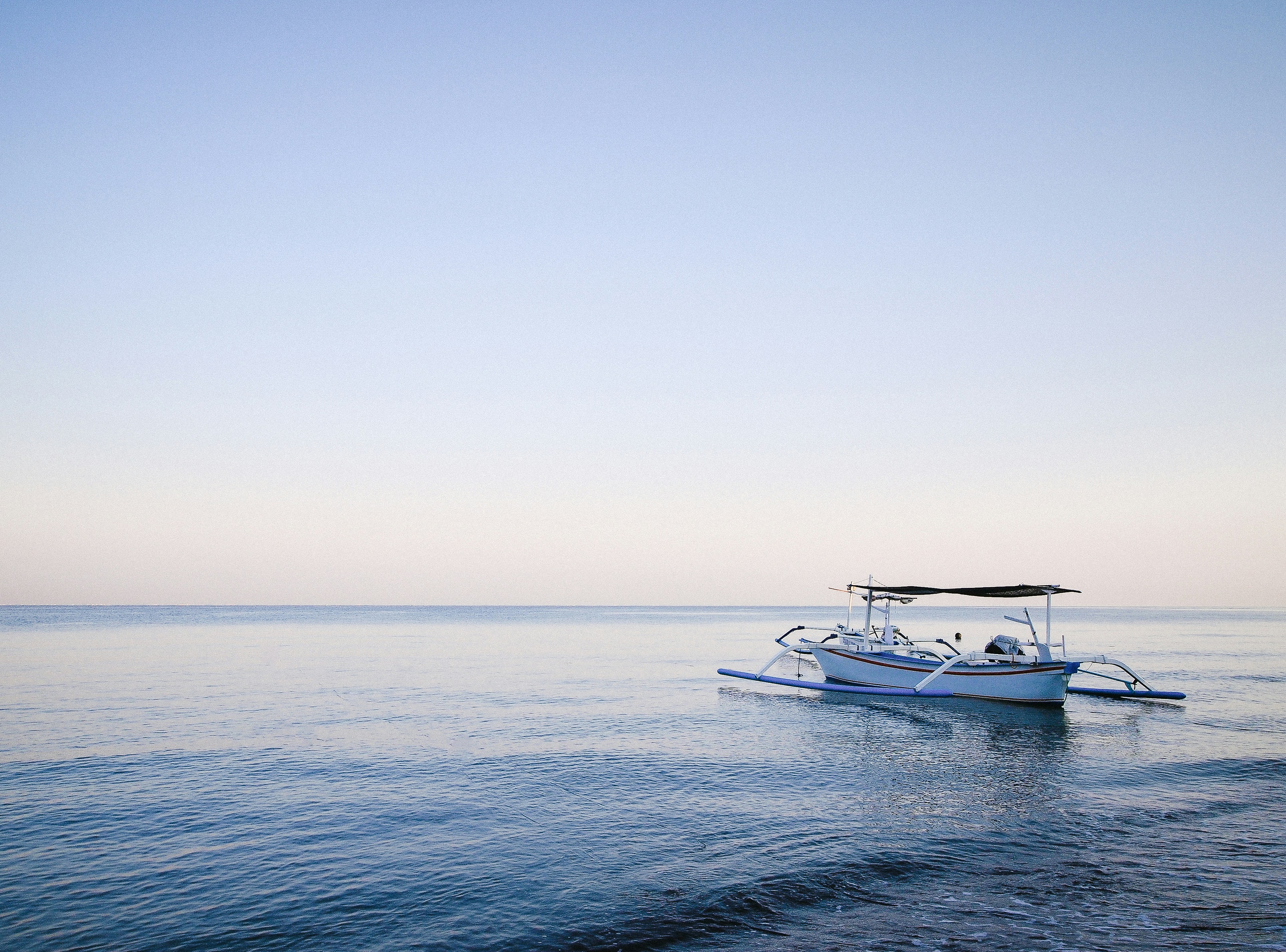 Barco tradicional balinés al amanecer en Lovina buscando delfines